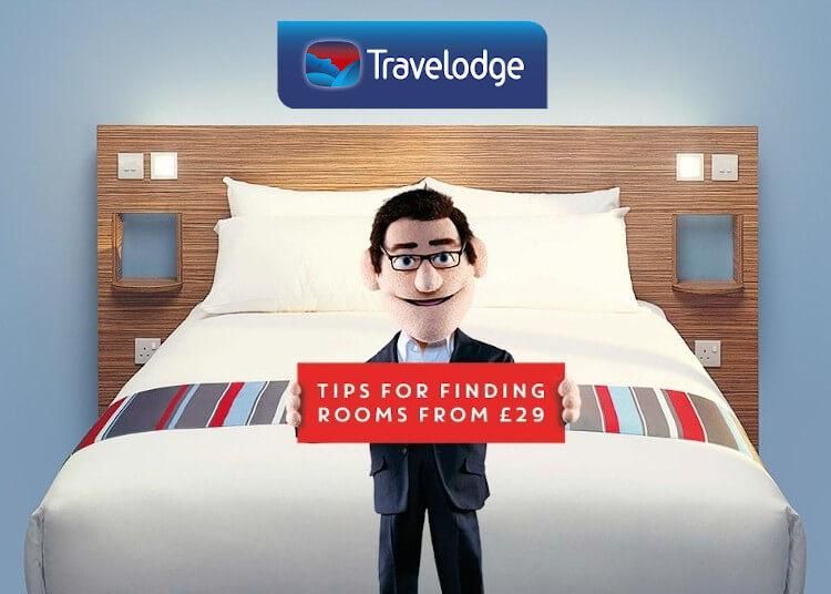travelodge-bedroom-showing-man-next-to-a-bed-holding-a-sign-offering-saver-room-rates